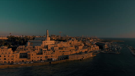 tel-aviv jaffa, flying over old jaffa port at sunset, tel-aviv skyline and the mediterranean sea at golden hour, israel, pedestal shot