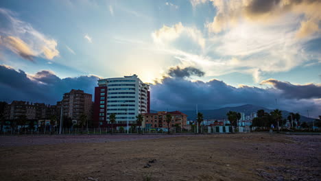 Timelapse-Con-Vibrantes-Nubes-Al-Atardecer-Moviéndose-Detrás-De-Edificios-Cerca-De-Málaga,-España