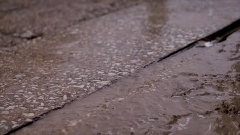 este video muestra gotas de lluvia cayendo sobre el hormigón en cámara lenta