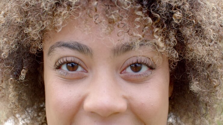 Close-up van een jonge biculturele vrouw met krullend haar en een subtiele glimlach