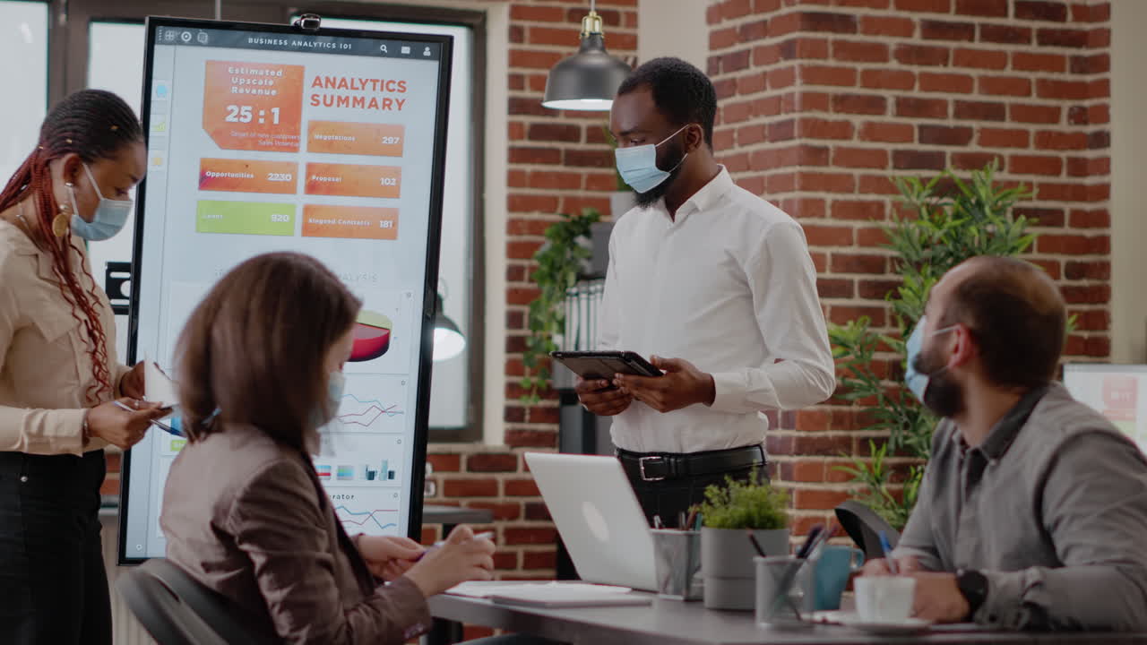 African american coworkers showing financial analysis on display