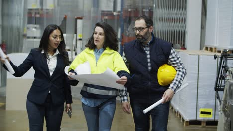 concentrated factory workers discussing plan of printing house