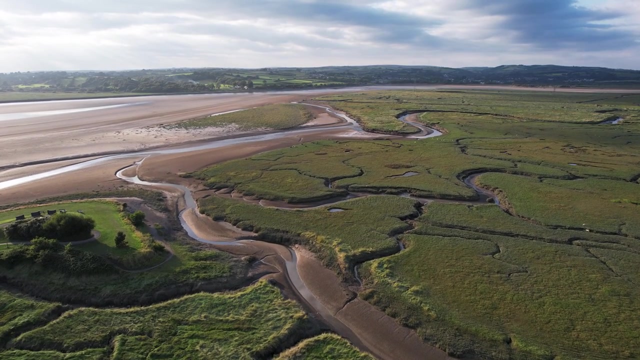 Riprese aeree: filmato in ascesa attraverso l'estuario sopra un gruppo di uccelli marini durante il tramonto, Gower, Drone 4K