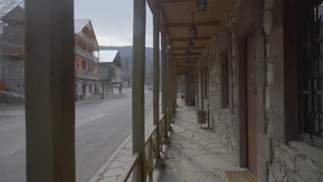 mountain village street with stone buildings and wooden porches