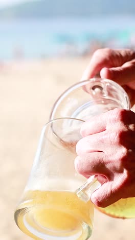 un hombre vierte cerveza en una playa soleada.