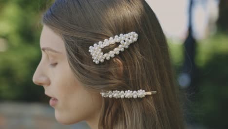 Attractive-Girl-Wearing-Pearl-Hair-Clips-On-Her-Long-Blonde-Hair-During-Daytime-At-The-Park