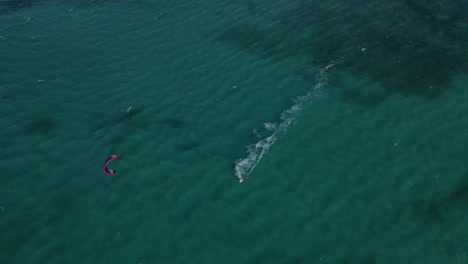 vuelo aéreo que muestra kite surf surf en el océano pacífico claro durante el hermoso clima exterior