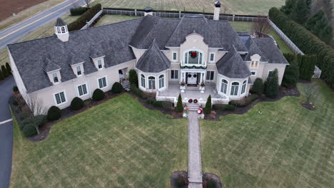 sprawling mansion home decorated with christmas wreath and lights