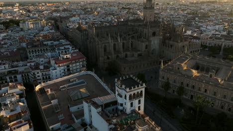 Flying-Towards-Catedral-de-Sevilla-In-Seville,-Spain-At-Sunrise---drone-shot