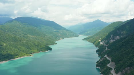 令人惊叹的空中全景山谷 绿色的湖泊 周围是绿色的茂密森林和山地道路