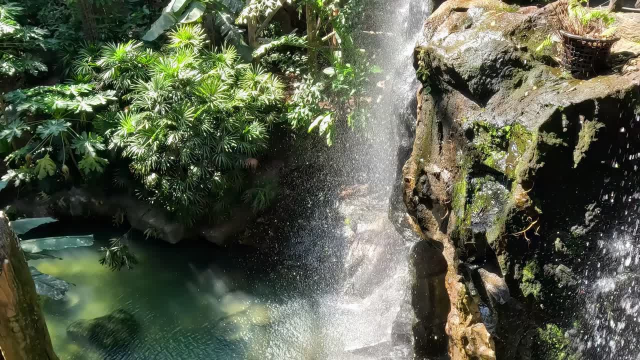 la cascada fluye junto a un puente de madera.