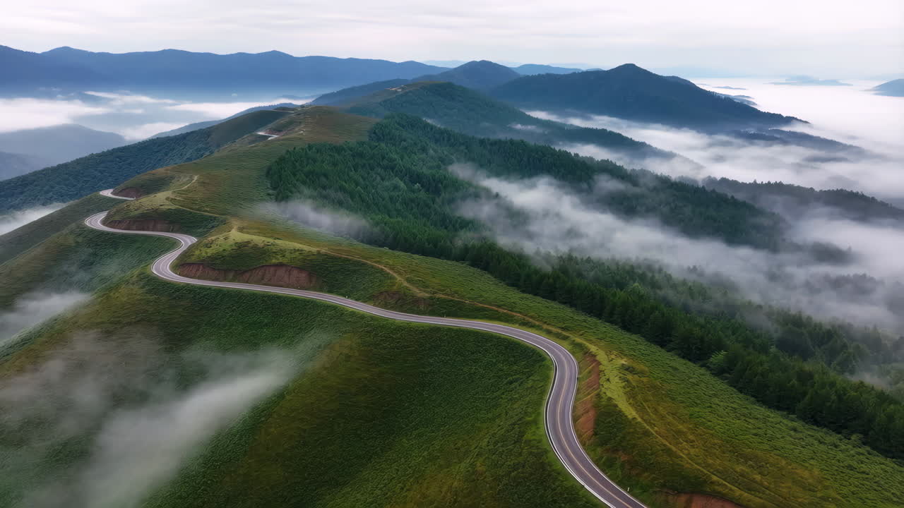 Winding Mountain Road Through Misty Peaks and Forests