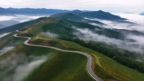 winding mountain road through misty peaks and forests