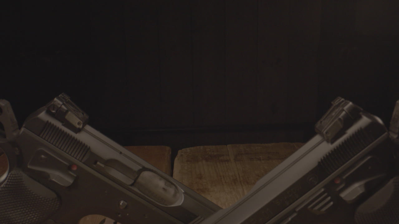 dolly sobre dos pistolas amartilladas sobre una superficie de madera