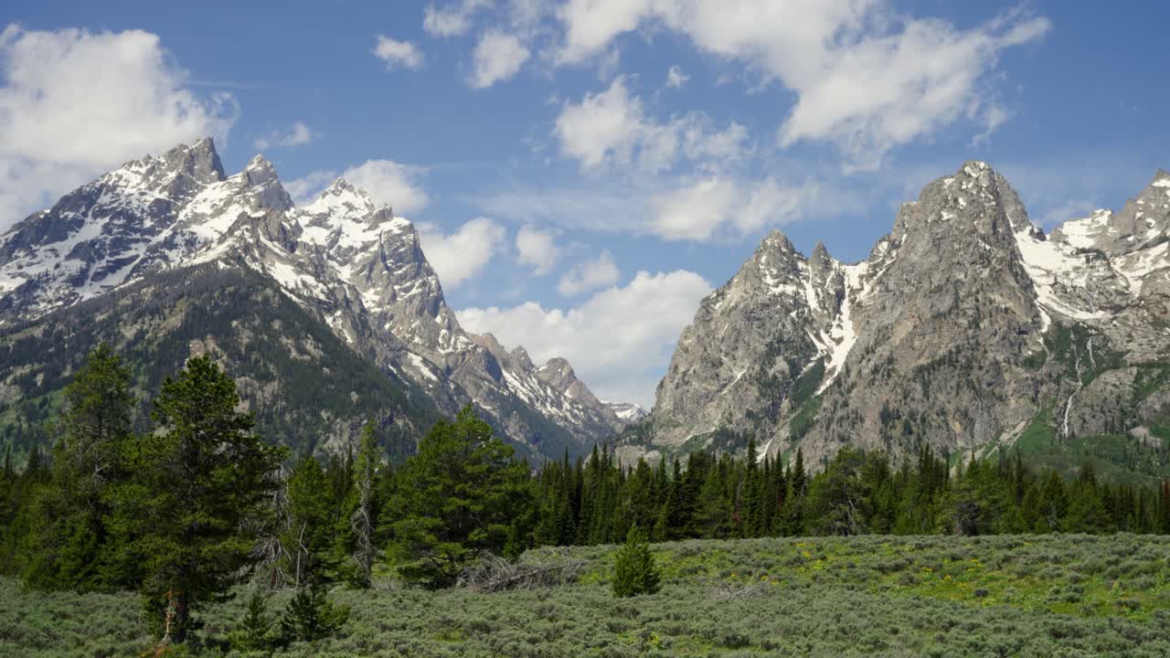 Cascade Canyon in Grand Teton National Park with the mountains covered in snow and a cloudy sky