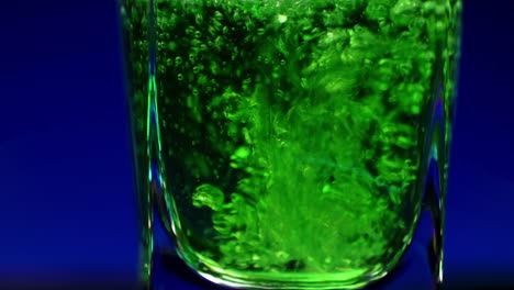 green liquid pouring into a glass