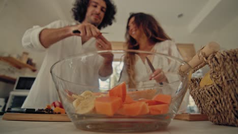 couple preparing a fruit salad