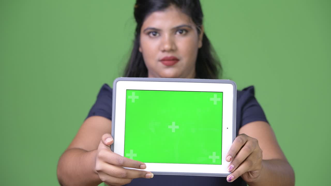 초록색 배경에 젊은 과체중 아름다운 인도 사업가