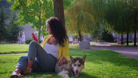 mujer relajándose en un parque con su perro