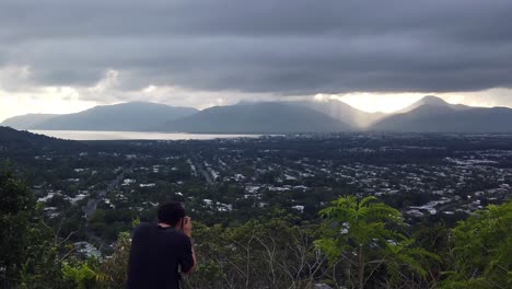 photographer taking photos of he sun rising over a distant mountain across the inlet