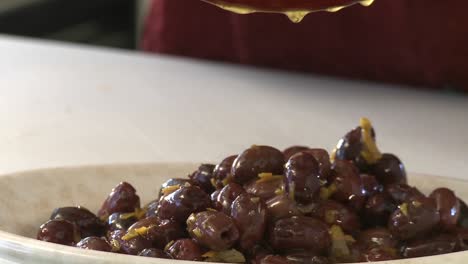 pouring olives from a bowl into a plate