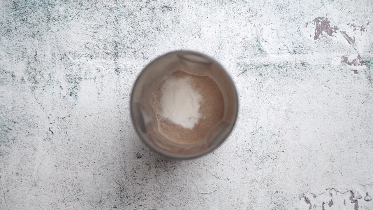 Preparing protein shake with scoop of powder