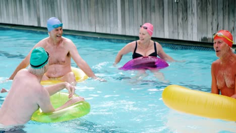 seniors with inflatable tubes enjoying in pool