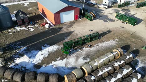 Aerial-Drone-Shot-of-Two-Women-Setting-up-a-Large-Green-Cattle-Chute-on-a-Farm