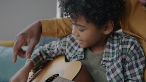 father teaching his son to play guitar