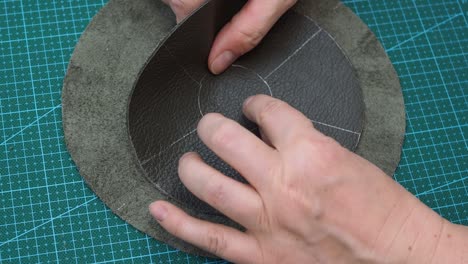 craftsman glues the details of the pouch using  soft hammer