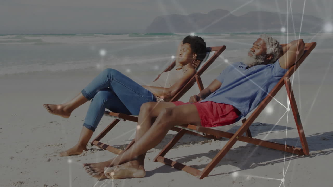 Couple reclining on wooden deck chairs, showing health chart and heart icon floating above waves