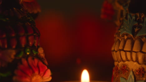 close up on still life of decorated skulls lit by candles celebrating mexican holiday of dia de muertos or day of the dead 10