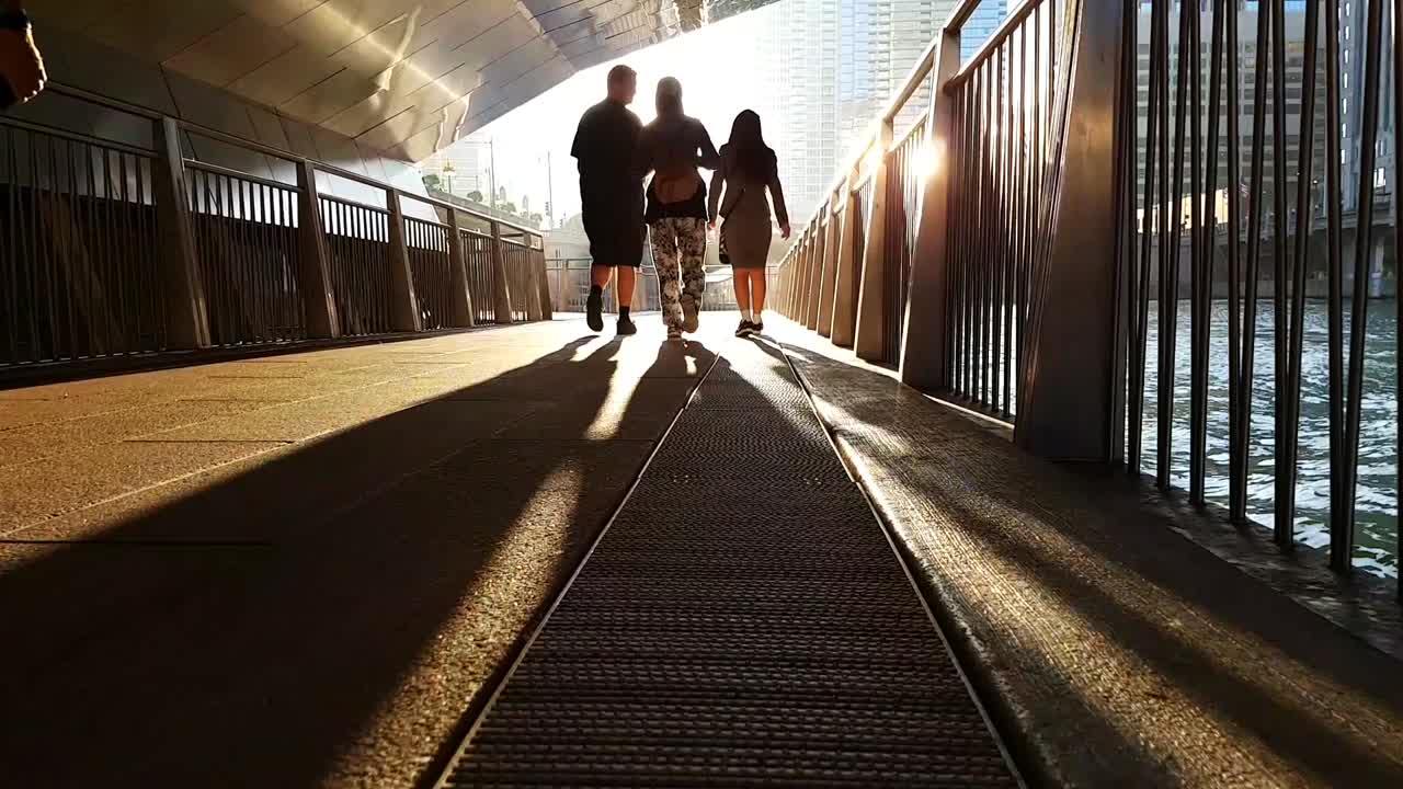 people walking relaxed enjoying the sunset in the city on the river, beautiful sunset