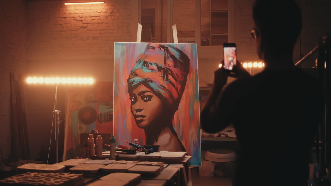 Artist taking a photo of their artwork in a studio