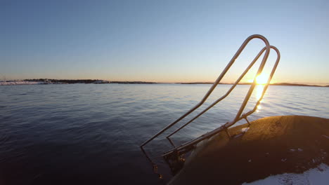 4k close-up of metal stairs for cold bathing at the shore of gothenburg, sweden on a cold winter sunset