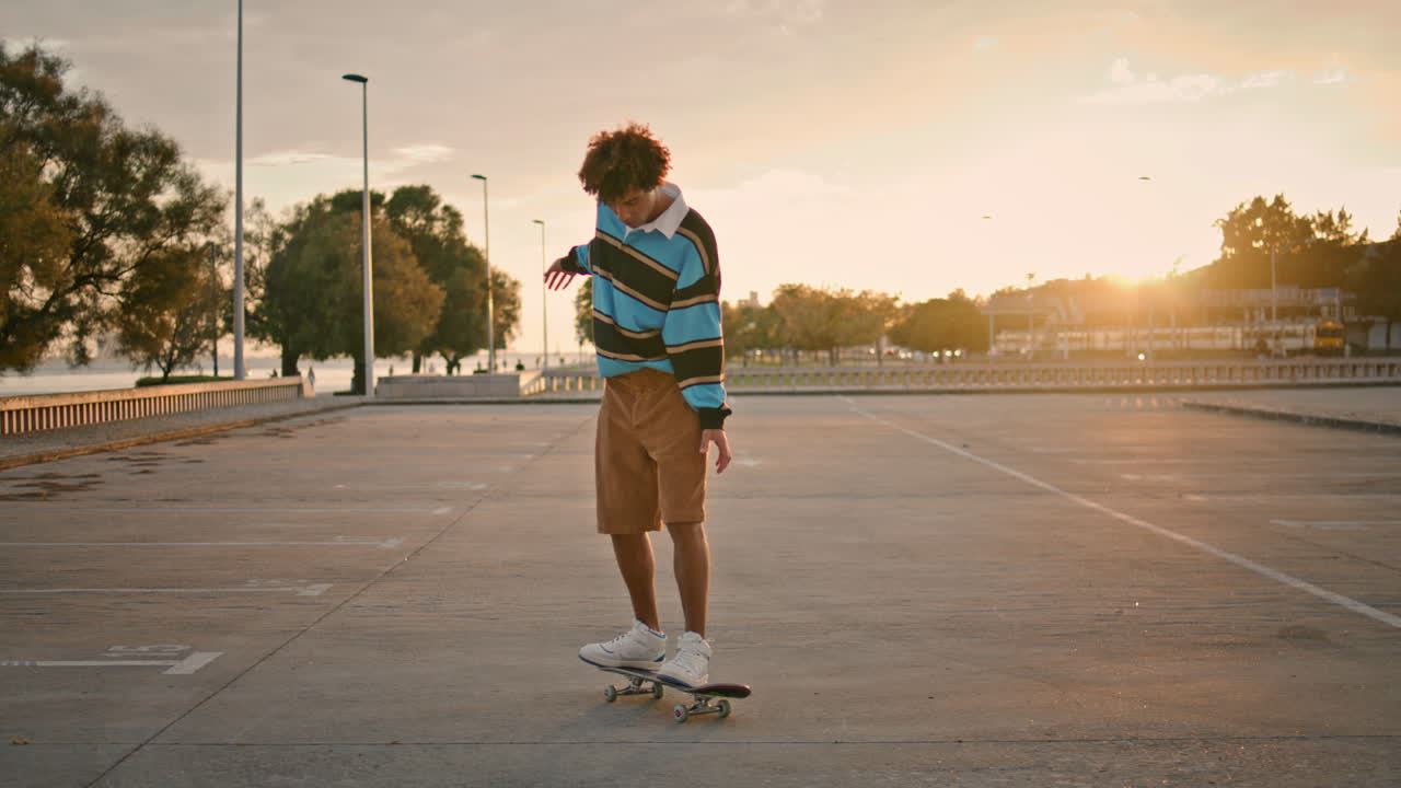 Rapaz estiloso pulando de skate ao pôr do sol. Jovem andando de skate.