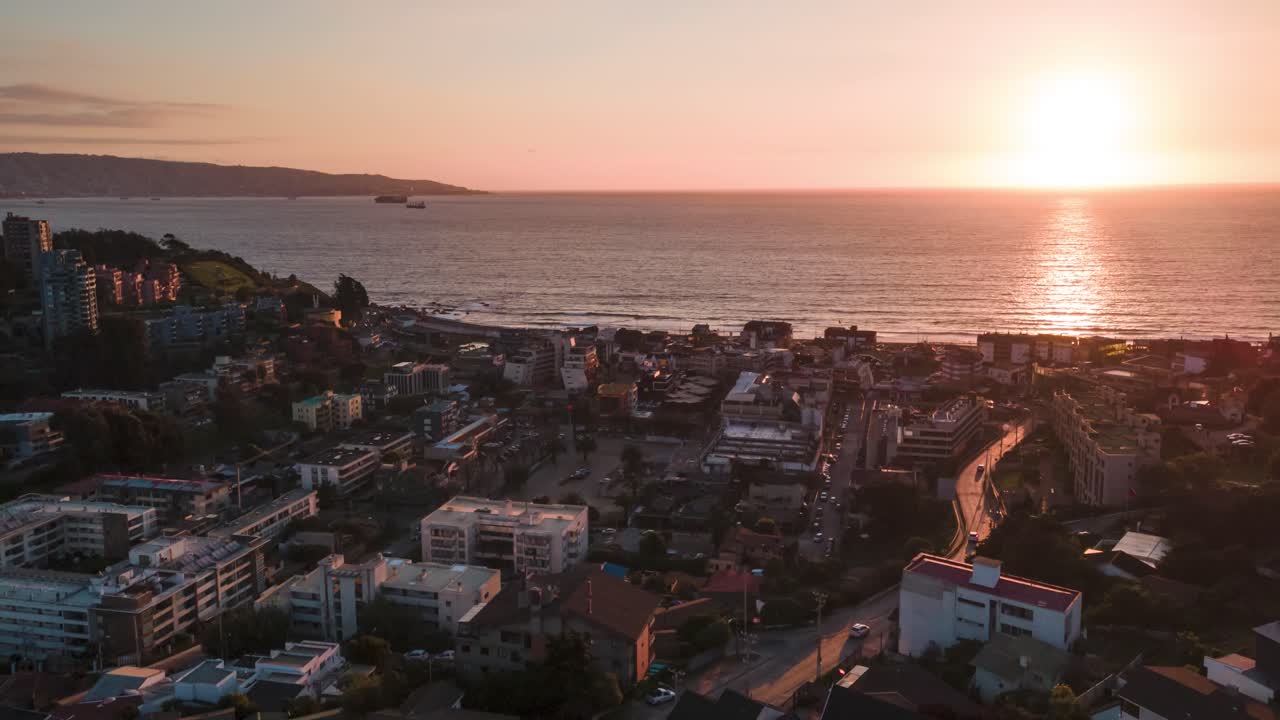 Aerial hyperlapse of the buildings in Renaca with the sun setting in the background