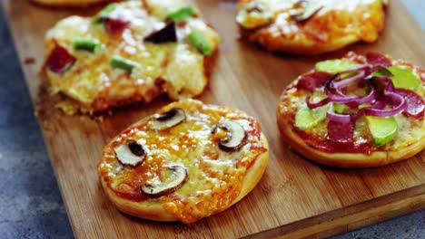 various pizzas on wooden board