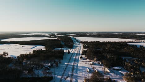 A rare snowfall blankets South Georgia, creating a stunning winter scene. This slow push-in drone shot captures a snow-covered highway amidst serene countryside views.