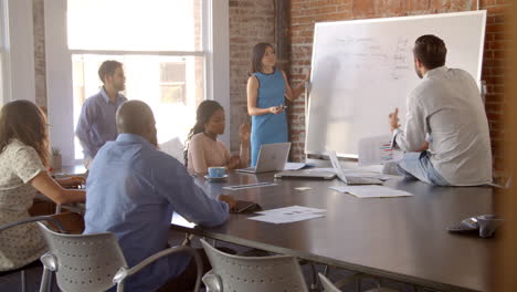 businesswoman at whiteboard in office giving presentation