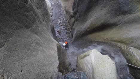 mujer barranquista rapela cascada en el cañón de piedra caliza muy por debajo