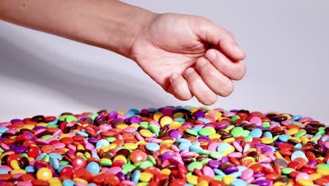 hands sorting colorful candies on a table