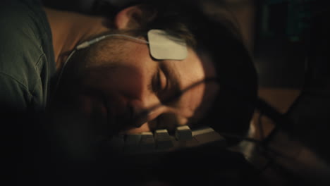 el hombre descansa la cabeza en el teclado, luego abre los ojos y se despierta con electrodos en la cabeza