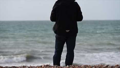 Stürmisches-Meer,-Blick-Vom-Strand-Von-Brighton,-Ein-Mann-Trägt-Schwarz-Und-Fliegt-Eine-Drohne