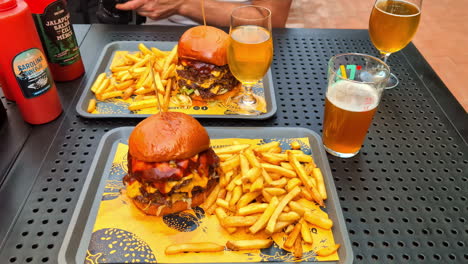 two delicious double cheeseburgers with fries and beer