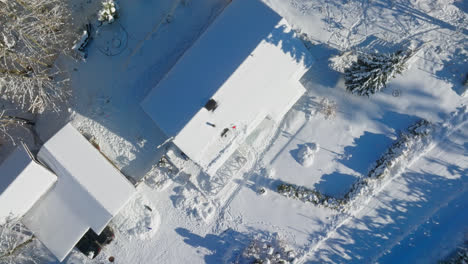 vista aérea girando por encima de las herramientas en paneles solares parcialmente nevados en el techo de una casa