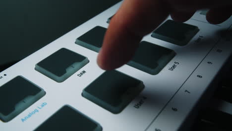 Close-up of a Hand Pressing a Button on an Analog Lab MIDI Keyboard Controller