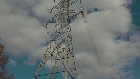 pilón de electricidad en medio de un campo de granjeros estéril con cables que se extienden por el campo