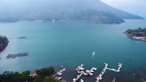 aerial view of lake atitlan, guatemala on misty day, turquoise water and coastal village
