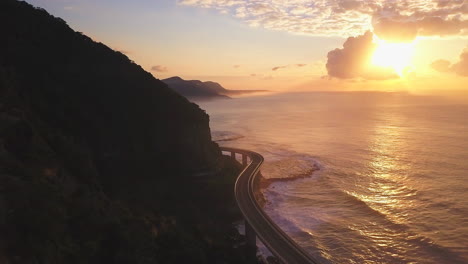 mar acantilado puente épico amanecer puesta de sol conduciendo sobre el océano australia impresionante costa material de anuncio de televisión dron de taylor brant película